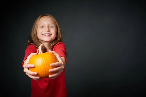 Happy girl giving you a ripe pumpkin — Stock Photo, Image