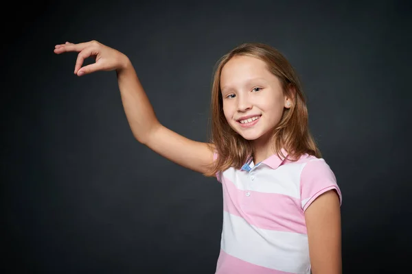 Χαμογελαστό κορίτσι εκμετάλλευση φανταστικό νήμα με τα δάχτυλά της — Φωτογραφία Αρχείου