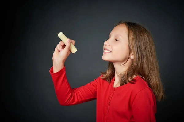 Meisje houdt een krijt wijzend op de lege kopie ruimte voor uw tekst — Stockfoto