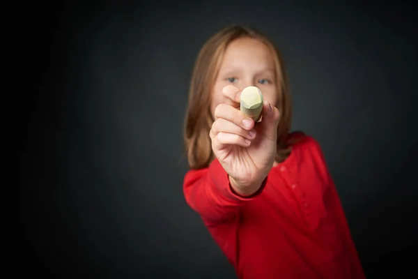 Meisje houdt een krijt wijzend op de lege kopie ruimte voor uw tekst — Stockfoto