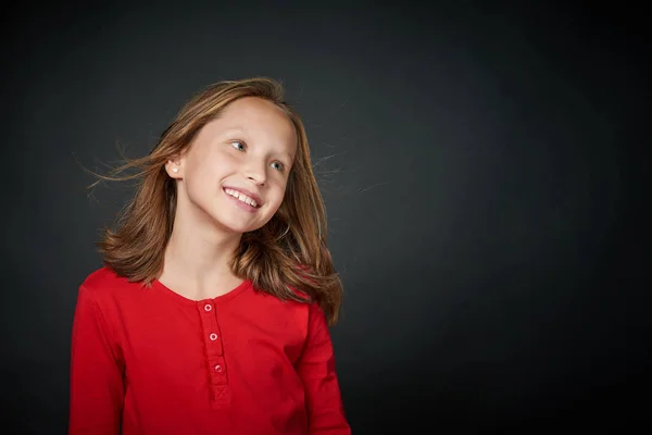 Happy girl with hair flying on wind looking to side at blank copy space — Stock Photo, Image