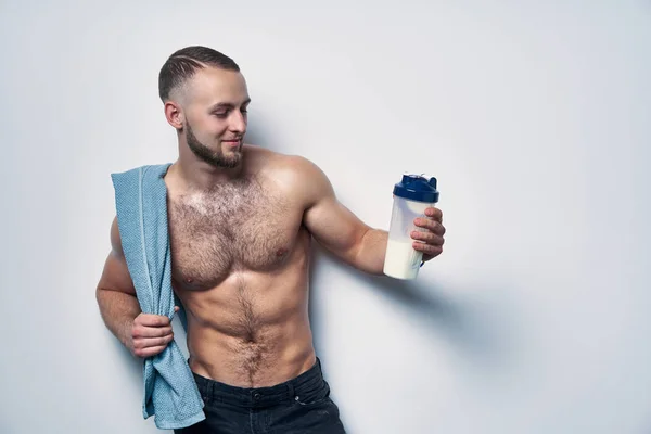 Ung muskulös man bar överkropp med handduk över axlar holding protein drink — Stockfoto