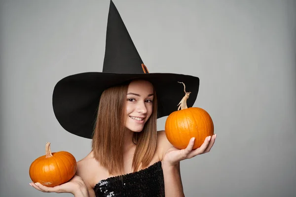 Gros plan de sorcière Halloween ludique tenant des citrouilles — Photo