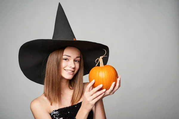 Närbild av lekfulla Halloween häxa hålla pumpa — Stockfoto