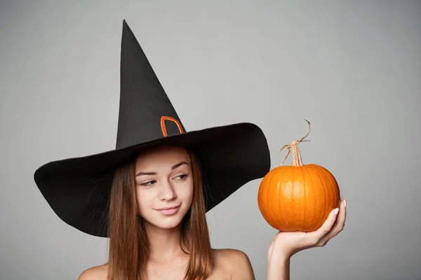 Vértes játékos Halloween boszorkány tartja a sütőtök — Stock Fotó