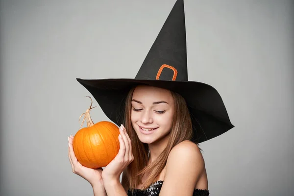 Närbild av lekfulla Halloween häxa hålla pumpa — Stockfoto