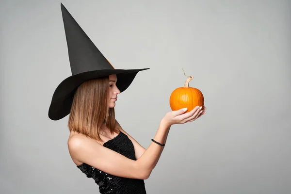 Vértes játékos Halloween boszorkány tartja a sütőtök — Stock Fotó