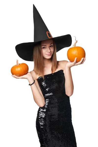 Halloween meisje heks hoed in de hand houden van pompoenen — Stockfoto