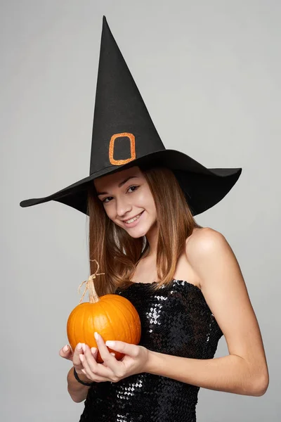 Närbild av lekfulla Halloween häxa holding pumpor — Stockfoto