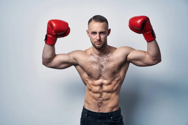 Hombre musculoso sin camisa que usa guantes de caja con las manos levantadas — Foto de Stock