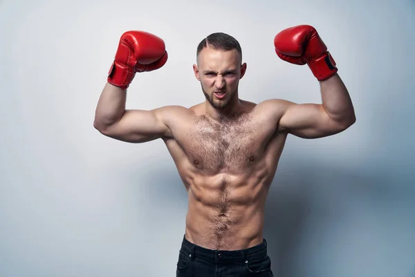 Hombre musculoso sin camisa que usa guantes de caja con las manos levantadas — Foto de Stock