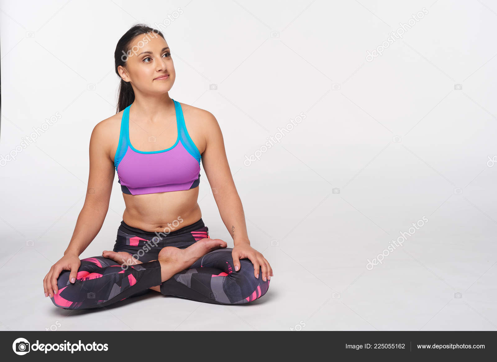 Woman sitting in yoga Padmasana, lotus pose Stock Photo by ©pavel_kolotenko  225055162