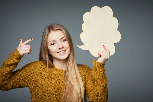 Menina em suéter segurando fala bolha sorrindo — Fotografia de Stock