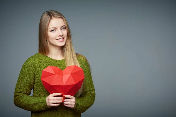 Portret van mooi blond meisje houdt hart vorm — Stockfoto