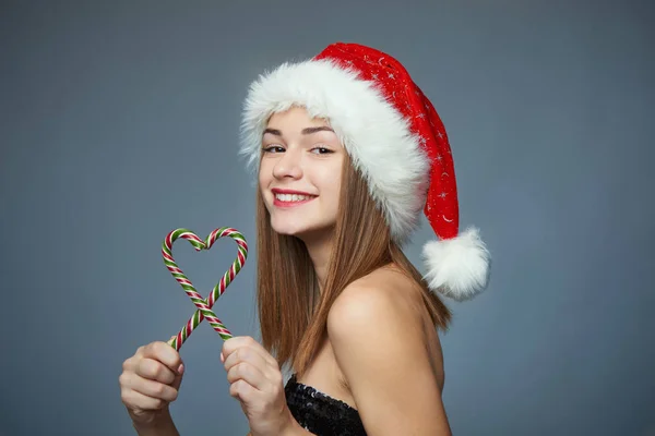 산타 모자 심장 모양에서 크리스마스 사탕을 들고 소녀 — 스톡 사진