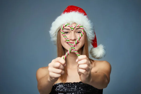 Meisje in KERSTMUTS bedrijf Kerstmis snoepjes in hart vorm — Stockfoto
