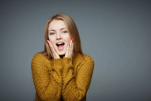Překvapený nadšeni blond dívka v svetr křiku radosti — Stock fotografie