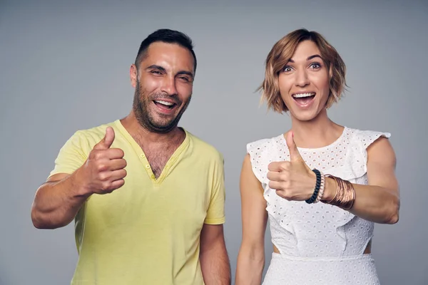 Feliz pareja emocionada riendo gesto pulgar hacia arriba —  Fotos de Stock