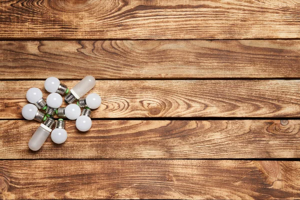 Two electric light bulbs on wooden planks — Stock Photo, Image