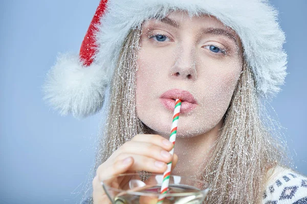 Kokteyl içme Noel Baba şapkası giyen yüz karda donmuş kızla — Stok fotoğraf