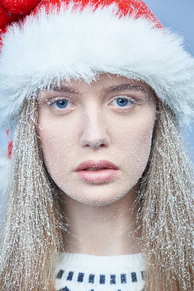 Chica congelada con nieve en la cara con sombrero de Santa —  Fotos de Stock