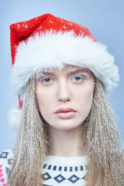 Menina congelada com neve no rosto usando chapéu de Papai Noel — Fotografia de Stock