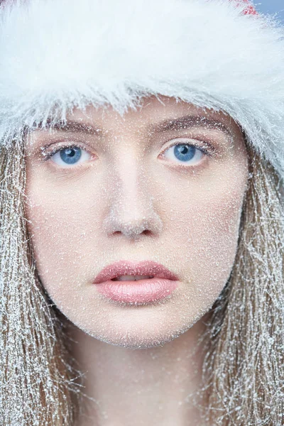 Chica congelada con nieve en la cara con sombrero de Santa —  Fotos de Stock