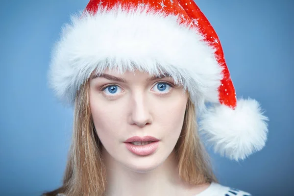 Close-up de uma mulher usando chapéu de Papai Noel, olhando para a câmera — Fotografia de Stock