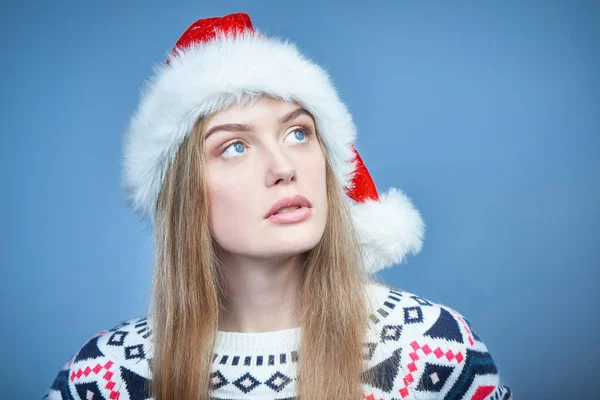 Mulher usando chapéu de Papai Noel olhando para o espaço de cópia com interesse — Fotografia de Stock