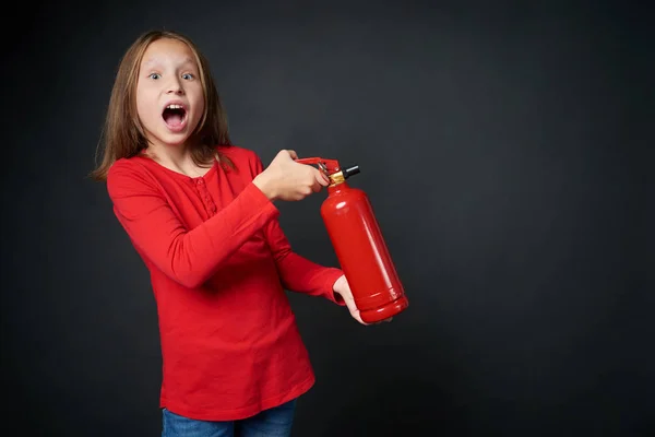 Chica sosteniendo extintor rojo dirigiendo en espacio de copia en blanco — Foto de Stock
