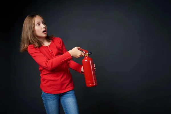 Chica sosteniendo extintor rojo dirigiendo en espacio de copia en blanco — Foto de Stock