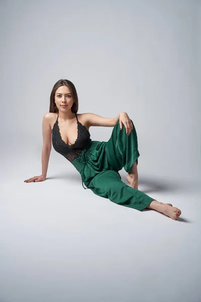 Femme brune sensuelle en pantalon vert et haut avec décolleté profond — Photo