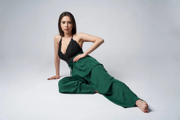 Sensual morena femenina en pantalones verdes y top con escote profundo — Foto de Stock