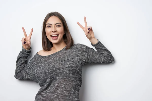 Feliz morena mulher gestos paz sinal sorrindo — Fotografia de Stock