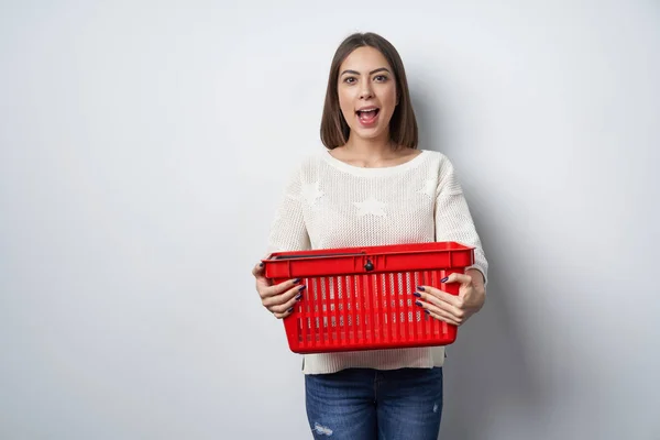 Excitada mulher surpreso segurando vazio cesto de compras — Fotografia de Stock