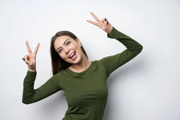 Glückliche brünette Frau gestikuliert Friedenszeichen lächelnd — Stockfoto