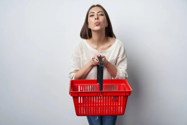 Szczęśliwa kobieta podając pusty koszyk wysyłanie pocałunek — Zdjęcie stockowe