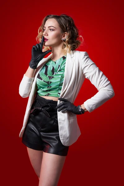 Fashionable female putting on rubber gloves over red — Stock Photo, Image