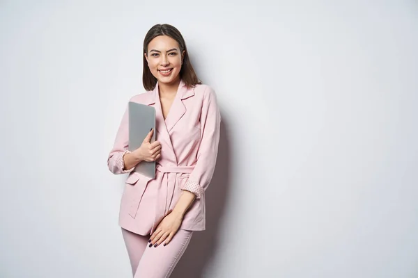Selbstbewusste Geschäftsfrau im rosafarbenen Anzug mit Laptop-Achselarm — Stockfoto