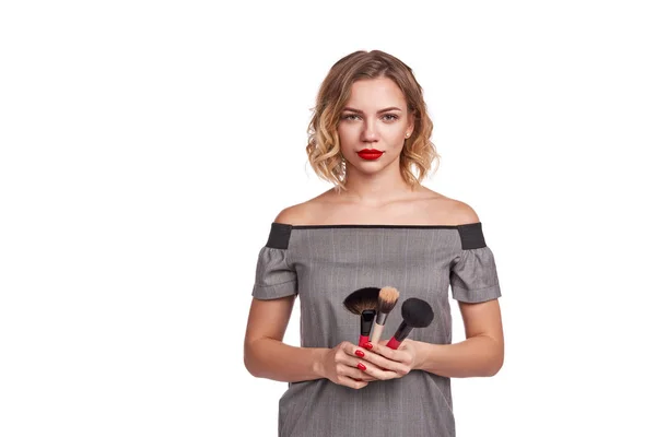 Portrait of female stylist standing with makeup brushes — Stock Photo, Image