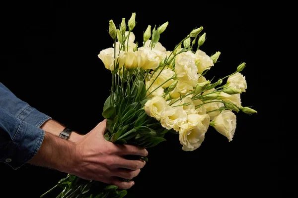 Mans hand presenting a bunch of flowers