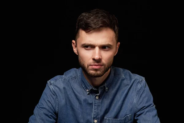 Man in denim overhemd op zoek zijwaarts met twijfelachtig expressie — Stockfoto