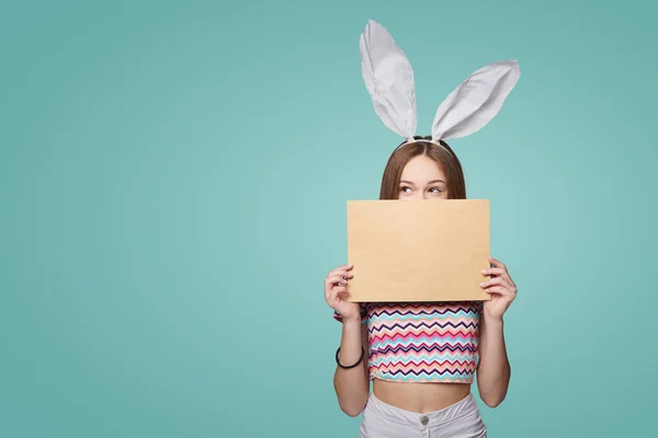 Дівчина в кролячих вухах тримає пусту літеру конверт — стокове фото