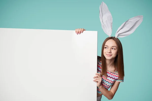 Dziewczyna ubrana w uszy królika, trzymając transparent — Zdjęcie stockowe