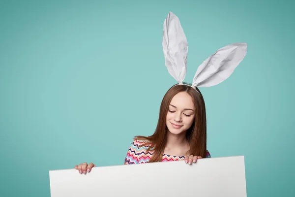 Chica con orejas de conejo sosteniendo una pancarta — Foto de Stock