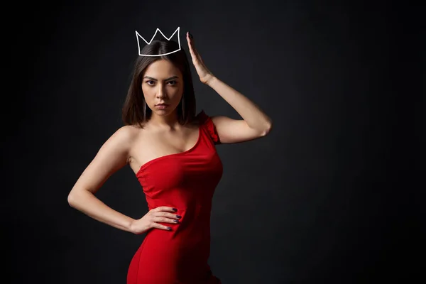 Piękna kobieta w czerwonej sukience, wspieranie jej korony — Zdjęcie stockowe