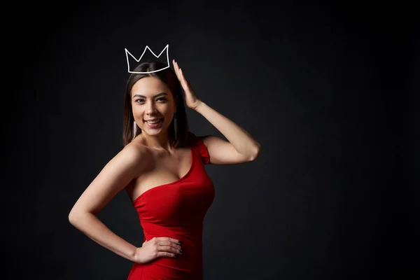 Hermosa mujer en vestido rojo que sostiene su corona —  Fotos de Stock