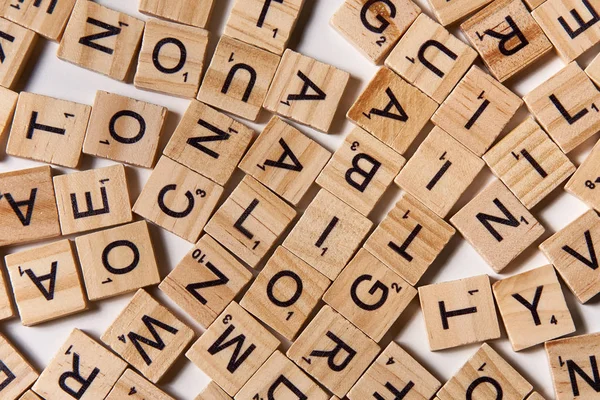 Rozrzucone litery alfabetu na kawałki drewniane scrabble — Zdjęcie stockowe
