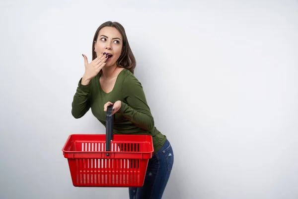 Mulher morena surpreso segurando vazio cesta de compras — Fotografia de Stock