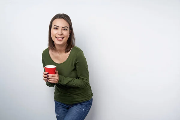 Mulher morena calma segurando caneca de papel descartável — Fotografia de Stock